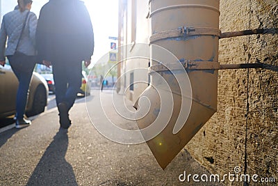 The silhouette of passers-by on a small city street. Woman holding a man by the arm, walking on the sidewalk. Sunset Stock Photo