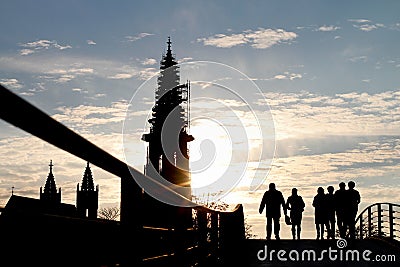 Silhouette of pedestrians on bridge in ront of mÃ¼nster Stock Photo