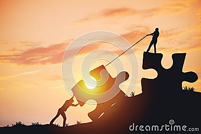 Silhouette people helping to connect jigsaw and puzzle to success Stock Photo