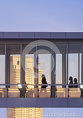 Silhouette of people walking on the elevated glass walkway in golden hour time at Bangkok, THailand at sunset time Editorial Stock Photo