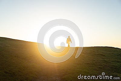 Silhouette of Person against Sunrise on a Hill. Lifestyle and Nature Concept Stock Photo