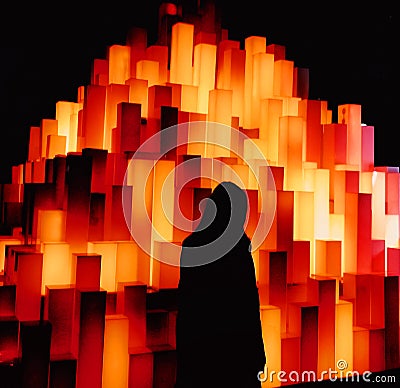 Silhouette watching the vertical bars in dimmed darkness. Stock Photo