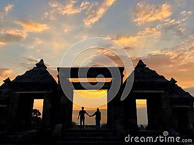a silhouette photo of a pair of lovers at the gate of a temple called Ratu Boko temple. a cultural tourism area in Yogyakarta Stock Photo