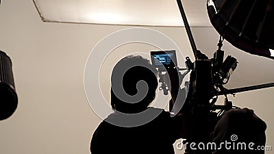 Silhouette of photographer checking for movie camera. Stock Photo