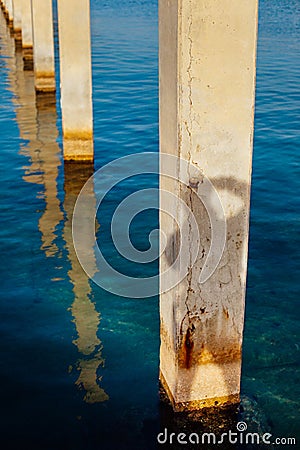 Silhouette of a photographer on some concrete poles in the water Stock Photo