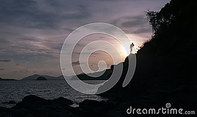 Silhouette of a photographer or traveler using a professional DSLR camera,photographer take sunset photo scenery view Stock Photo