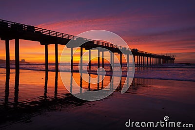 Silhouette pier at beach and brilliant sunset Stock Photo