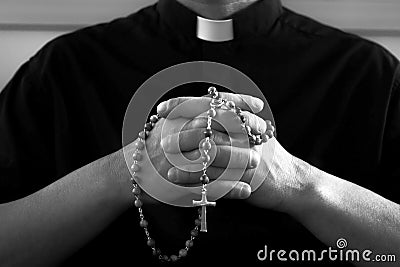 Praying priest with rosary beads Stock Photo