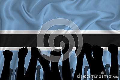 Silhouette of raised arms and clenched fists on the background of the flag of Botswana. The concept of power, conflict. With Stock Photo