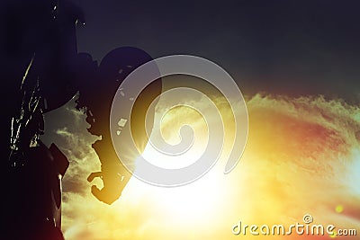 Silhouette rear of metal robot standing in sunset sky Stock Photo