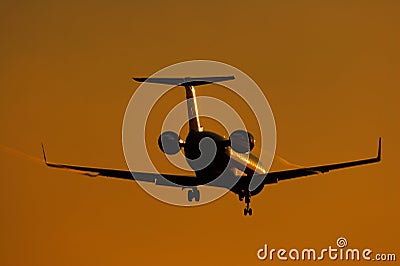Silhouette of regional jet facing sun Stock Photo