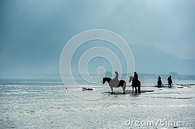 Silhouette of Riders at the beach riding horses Stock Photo