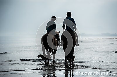 Silhouette of Riders at the beach riding horses Stock Photo