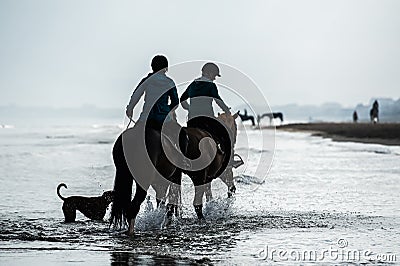 Silhouette of Riders at the beach riding horses Stock Photo