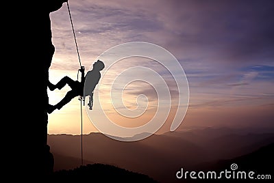 Silhouette of Rock Climber at Sunset Stock Photo