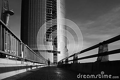 Silhouette's lonely people walking on the way to highrise buidl Editorial Stock Photo