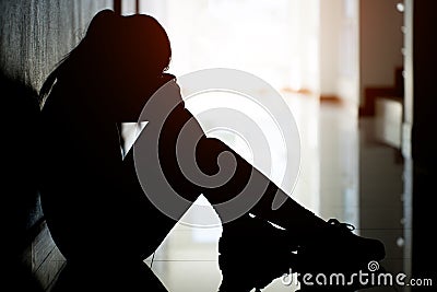 Silhouette of sad and depressed women sitting at walkway of condominium or office Stock Photo