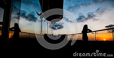 Silhouette scene of woman standing on balcony Stock Photo