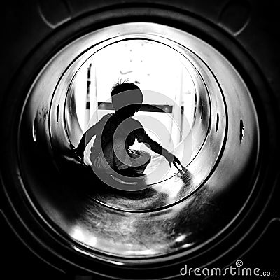 Silhouette of the sitting boy with light at the end of tunnel Stock Photo