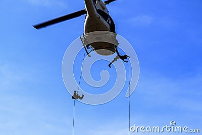 Silhouette Soldier Jump rope from helicopter in blue sky Stock Photo