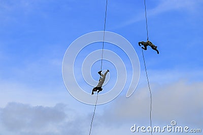 Silhouette Soldier Jump rope from helicopter in blue sky Stock Photo