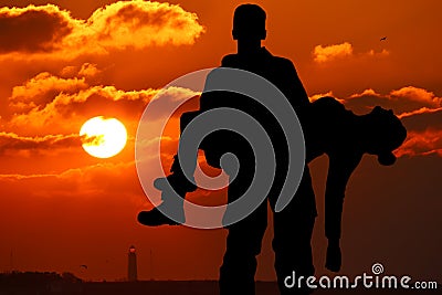 silhouette of a soldier officer man holding on hands girl woman Stock Photo