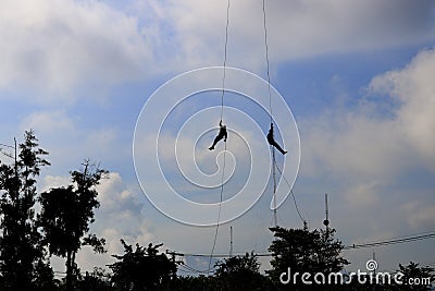 Silhouette Soldier rappelling from helicopter in blue sky Stock Photo