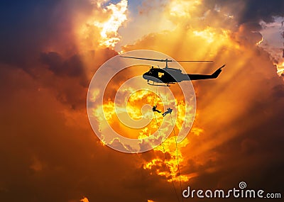 Silhouette soldiers in action rappelling climb down from helicopter with military mission counter terrorism assault training Stock Photo