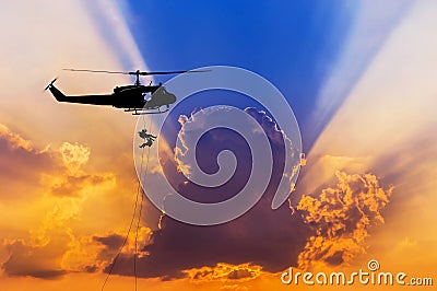 Silhouette soldiers in action rappelling climb down from helicopter with military mission counter terrorism assault training Stock Photo