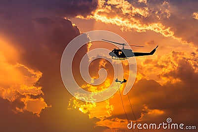 Silhouette soldiers in action rappelling climb down from helicopter with military mission counter terrorism Stock Photo