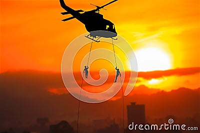 Silhouette Soldiers rappel down to attack from helicopter on with sunset and copy space add text Concept stop hostilities To pe Stock Photo