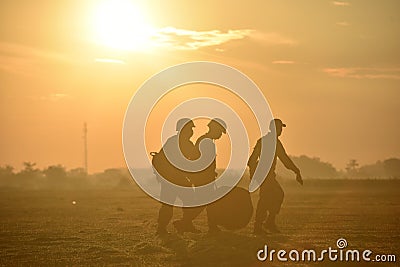 Silhouette of soldiers who help each other carry parachutes after skydiving Editorial Stock Photo