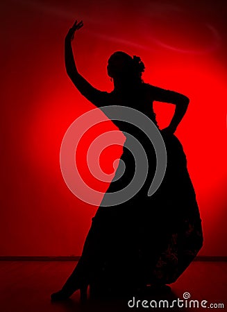 Silhouette of spanish girl flamenco dancer on a red background Stock Photo