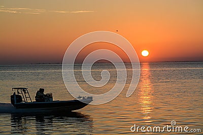 The silhouette of a speeding boat on Tampa Bay at Sunrise in St Petersburg, Florida. Editorial Stock Photo