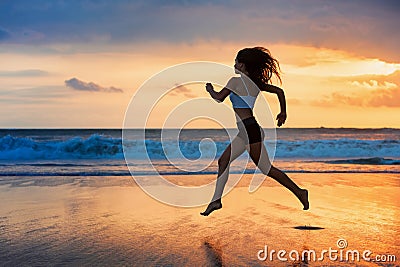 Silhouette of sporty girl running by beach sea surf pool Stock Photo