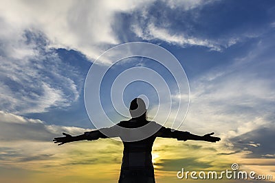 Silhouette of strong confidence woman open arms under the sunris Stock Photo