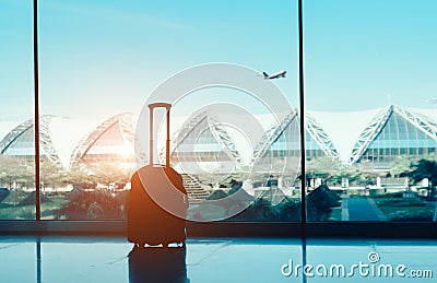 Silhouette suitcase,luggage on side window at airport terminal international and airplane outside on fly flight in the blue sky tr Stock Photo