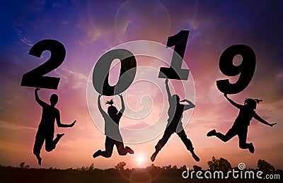 Silhouette sunset background and New year.They are jumping in to sky and lift 2019 word. Stock Photo