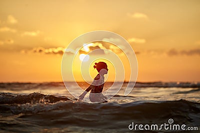 Silhouette at sunset.girl in the sunset.silhouette jump. Silhouette life and activity on the beach at dusk. Stock Photo