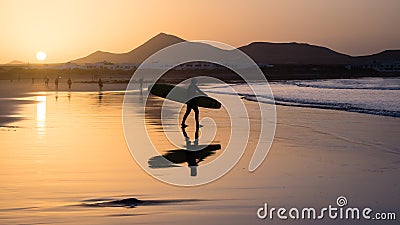 Silhouette of a Surfer on Famara beach at sunset Editorial Stock Photo