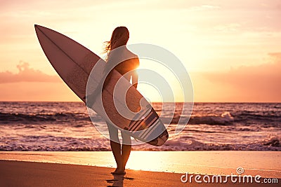 Silhouette surfer girl on the beach at sunset Stock Photo