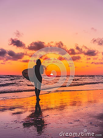 Silhouette of the surfer girl with surfboard on a beach at sunset. Surfer and ocean Stock Photo