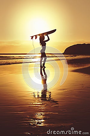 Silhouette of surfer standing with surf board on beach Stock Photo