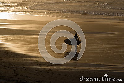 Silhouette of surfers in scenic golden sunset on hendaye beach, basque country, france Stock Photo