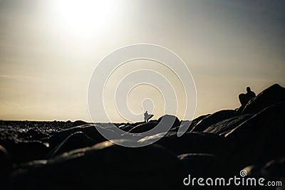 Surfers heading out alone at sunrise walking along the beach Editorial Stock Photo