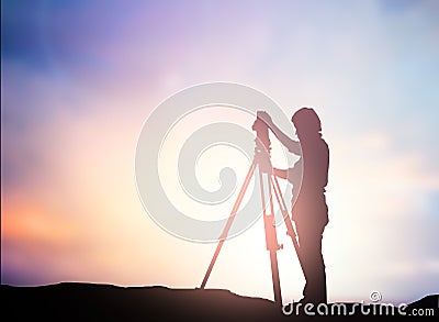 Silhouette survey engineer working in a building site over Blur Stock Photo