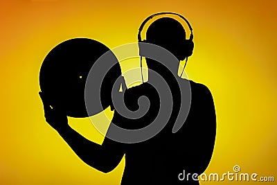 Silhouette of a teenager who holds the LP in front of yellow background Stock Photo