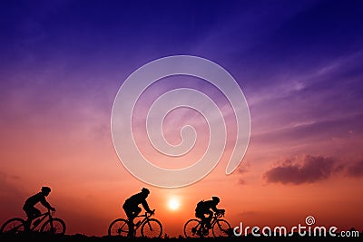 Silhouette three men ride bikes at sunset with orange-blue sky background Stock Photo