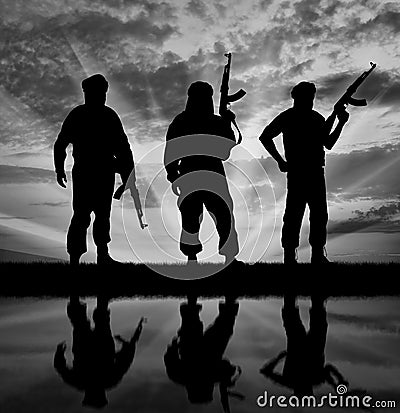 Silhouette of three terrorists Stock Photo