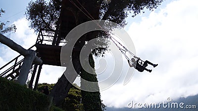 Silhouette of a tourist on a swing at Casa del Arbol Editorial Stock Photo